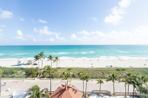 A beach view with palm trees, a lifeguard tower, and a lifeguard hut.