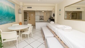 A hotel room with a bed, a small kitchenette, a dining area with a table and chairs, and a large mirror. - 703 Ocean View Hollywood Beach (Hollywood)