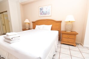 A neatly made bed with white linens and two bedside tables with lamps. - 705 Partial Ocean View Hollywood Beach Resort (Hollywood)
