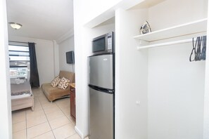 A compact living space with a kitchenette, including a refrigerator, microwave, and a small shelf. - 707 Partial Ocean Hollywood Beach (Hollywood)