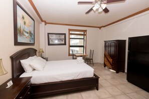 A hotel room with a bed, a desk, a chair, a wardrobe, and a ceiling fan. - 405 Ocean View Hollywood Beach (Hollywood)