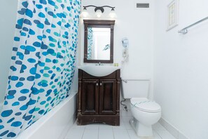 A bathroom with a bathtub, a sink, a toilet, and a mirror. - 584 Ocean View Studio Hollywood Beach (Hollywood)