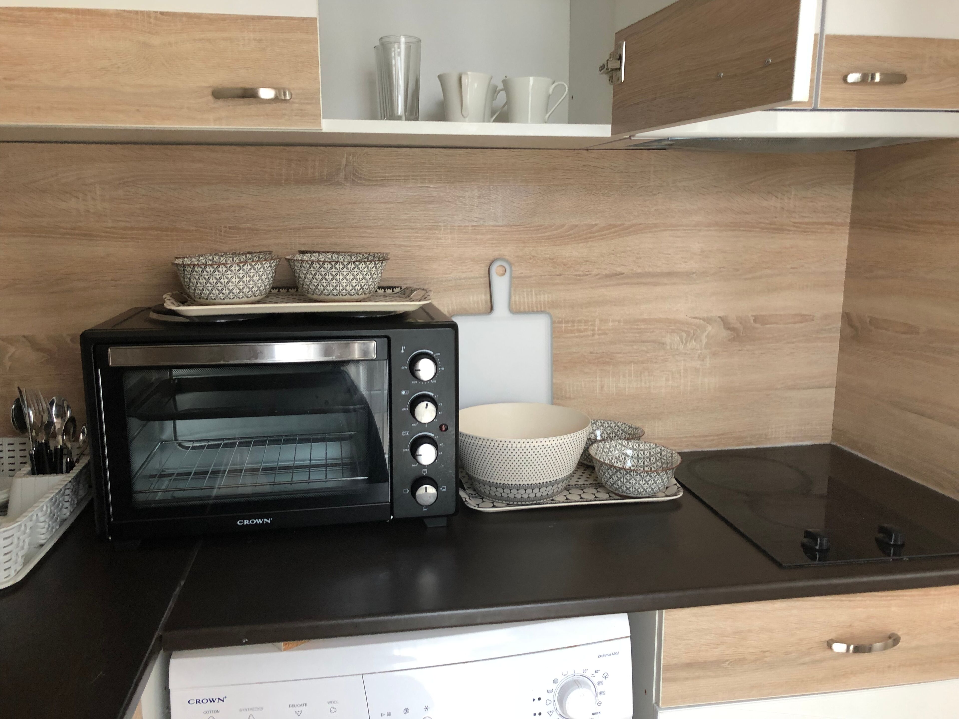 Una cocina equipada con horno empotrado, microondas y cafetera.