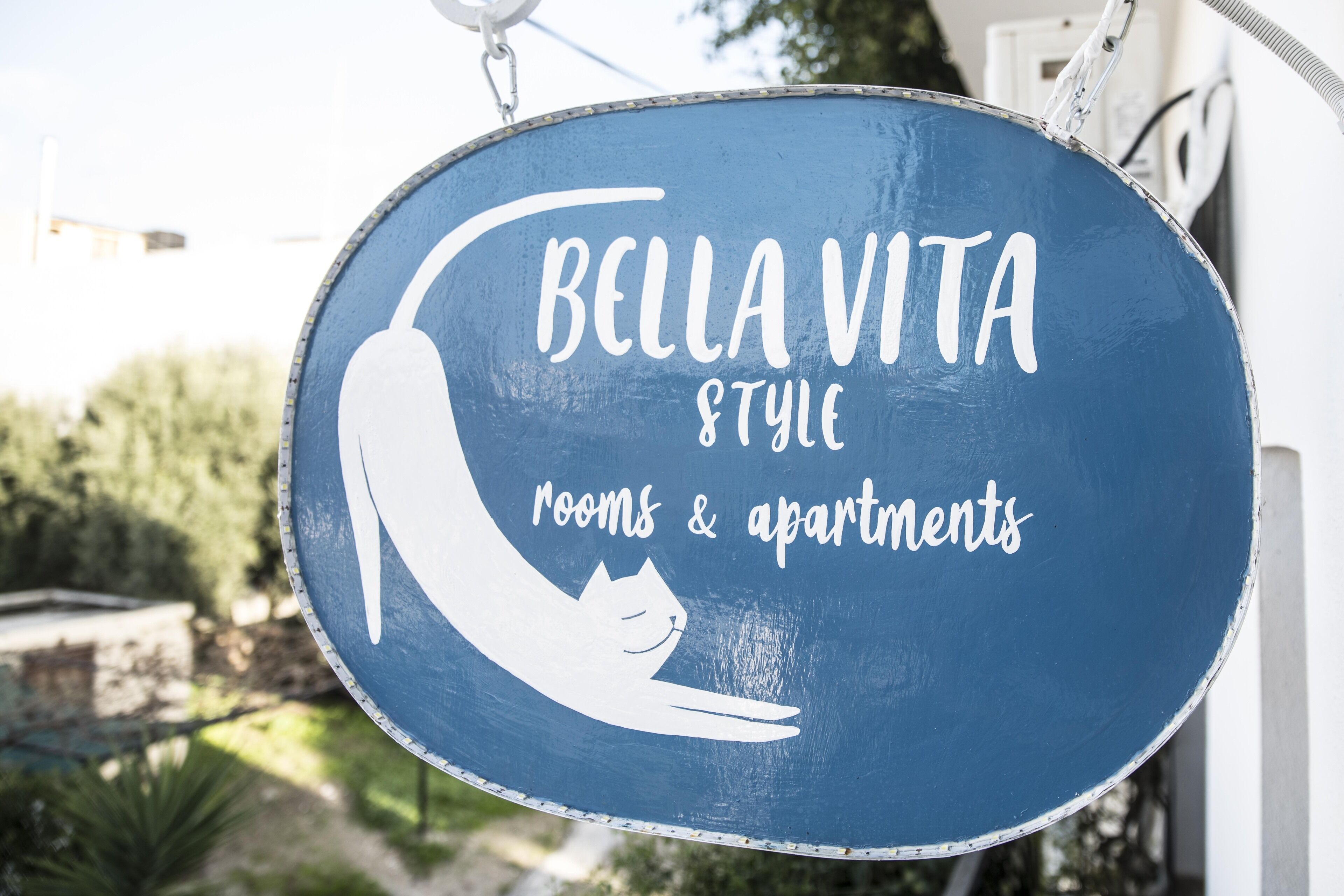 A sign for Bella Vita Style rooms & apartments with a cat silhouette.