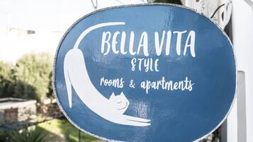 A sign for Bella Vita Style rooms & apartments with a cat silhouette.