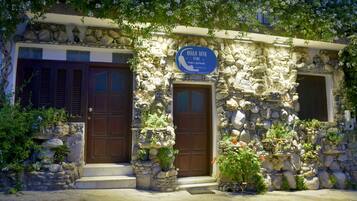 A stone building with two wooden doors and a sign that reads "Bella Vita Style."