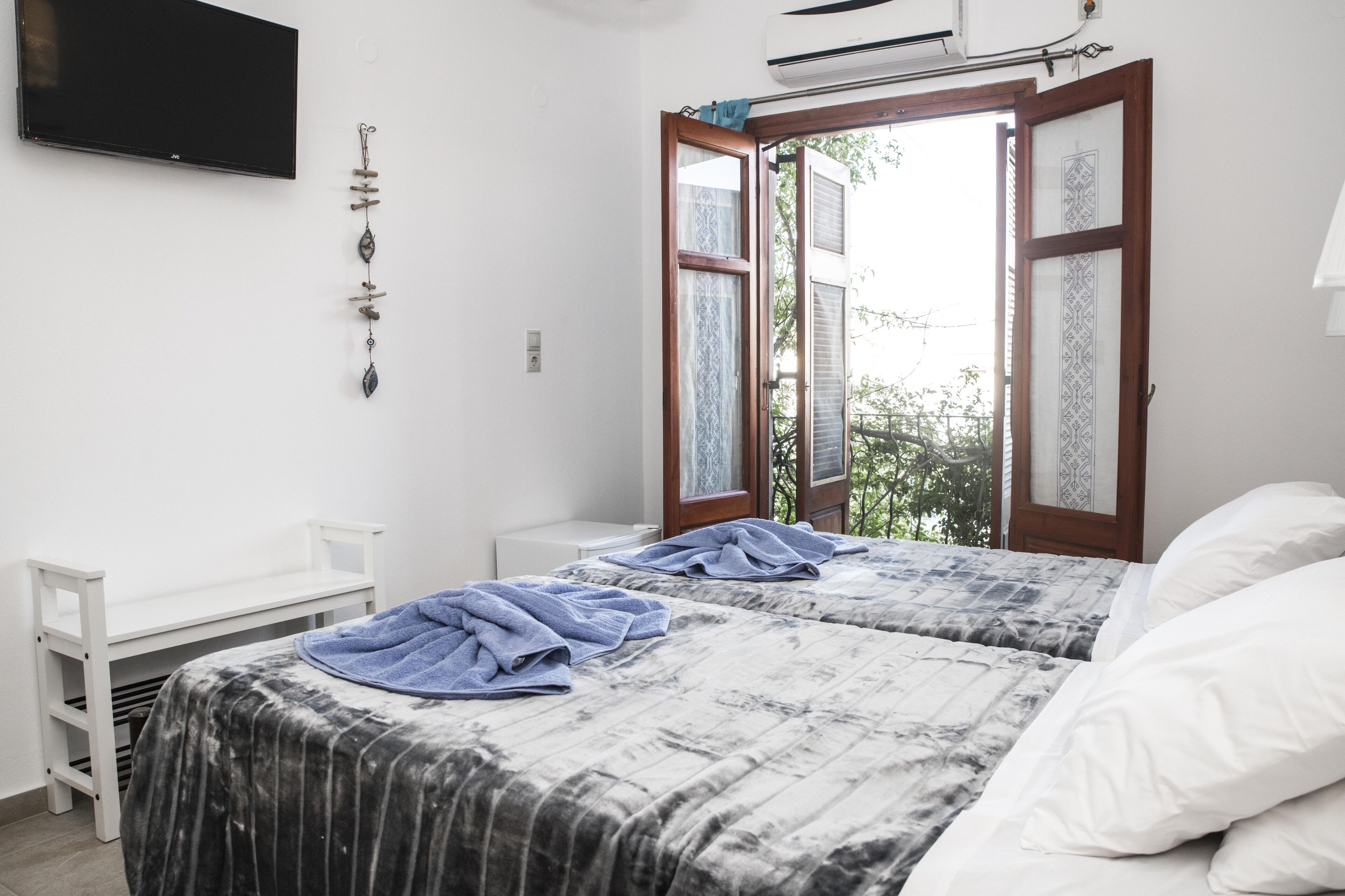 A bedroom with two beds, a desk, and a TV.