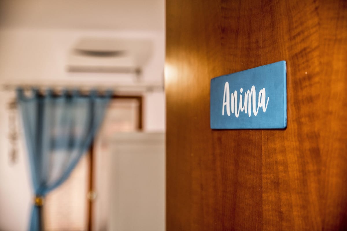 Une porte en bois avec une plaque portant le nom « Anima ».