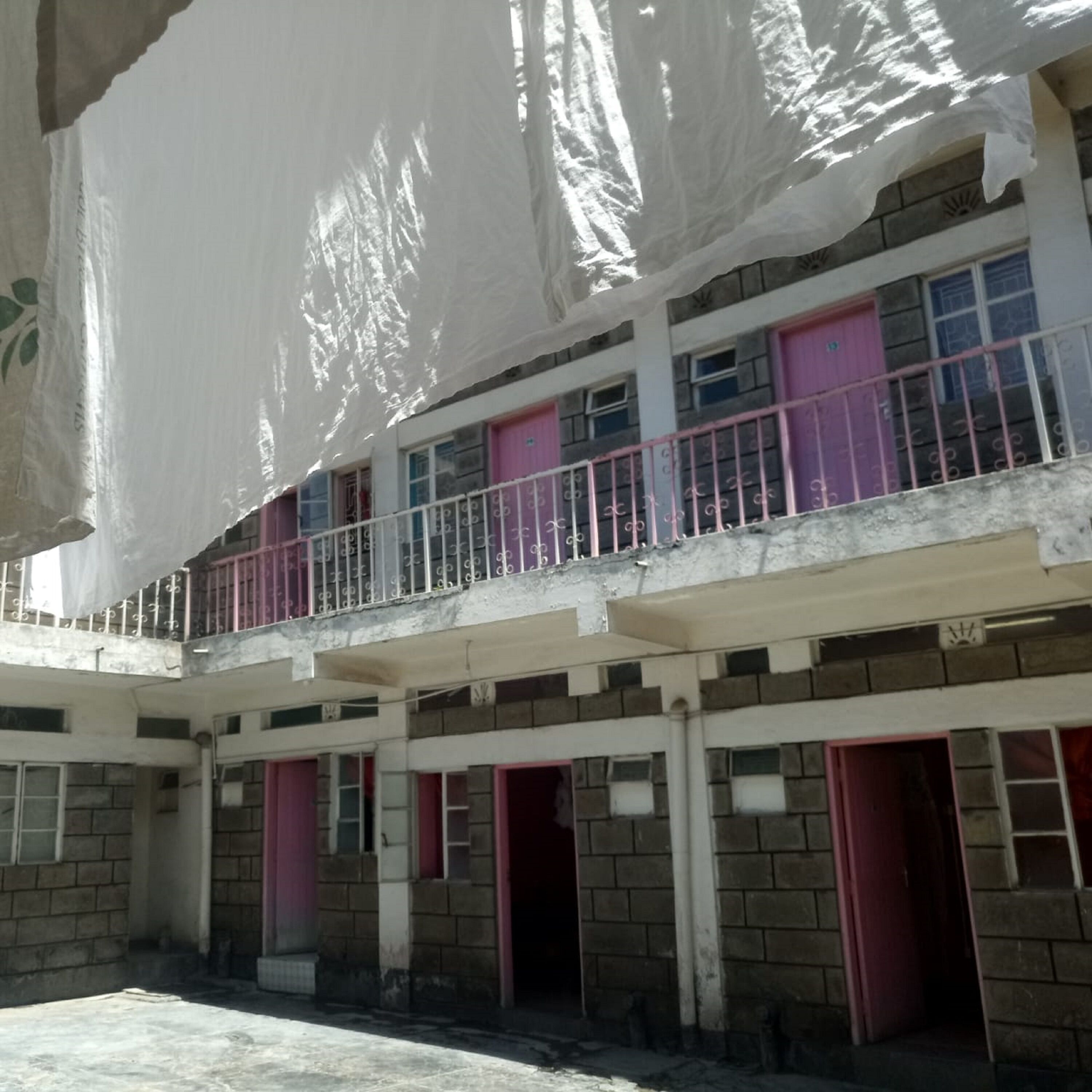 A multi-story building with balconies, brick walls, and multiple doors.