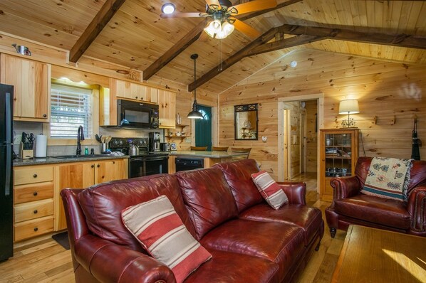 Cozy cabin interior with a dining area, kitchen, and comfortable seating for relaxation.