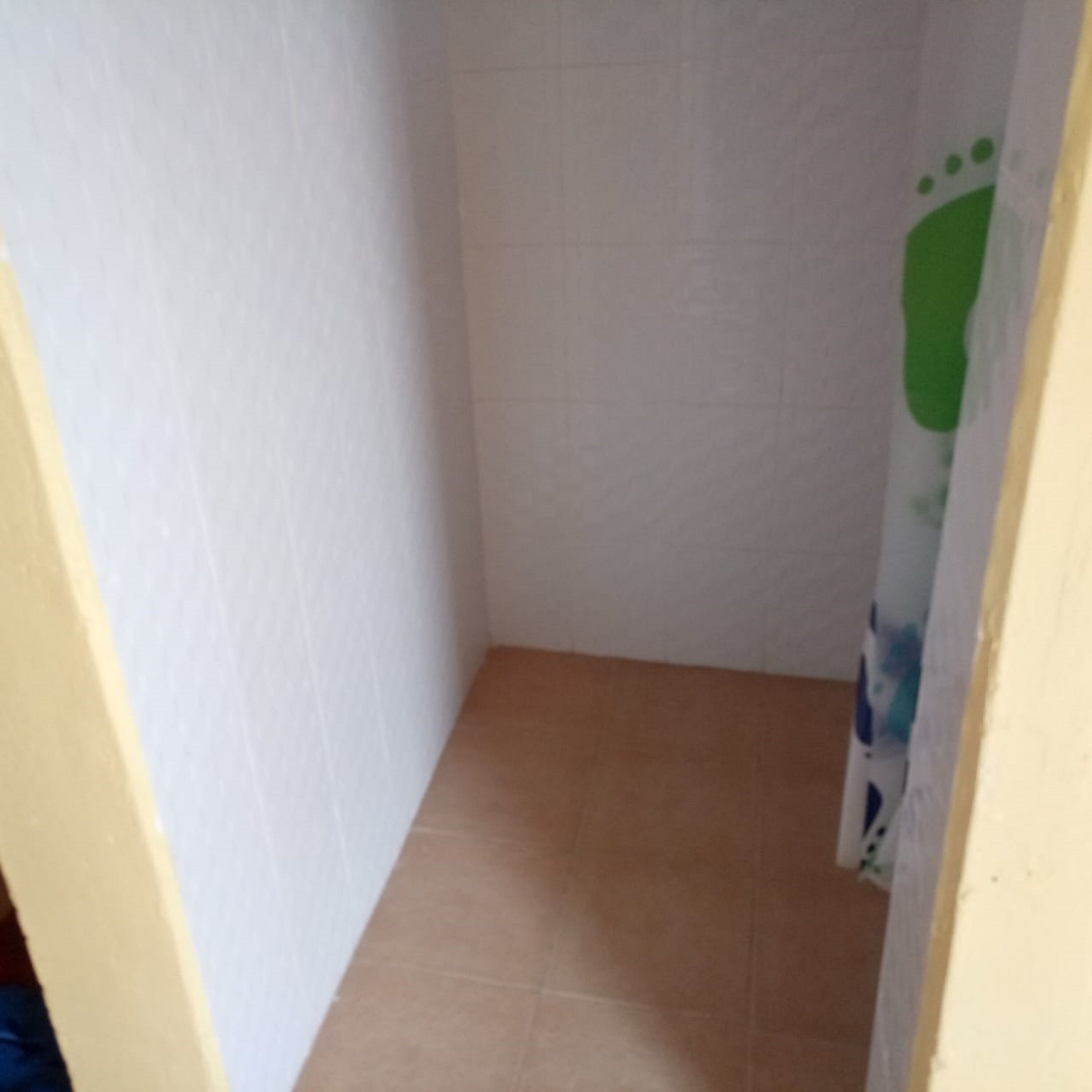 A narrow hallway with white walls and a tiled floor.