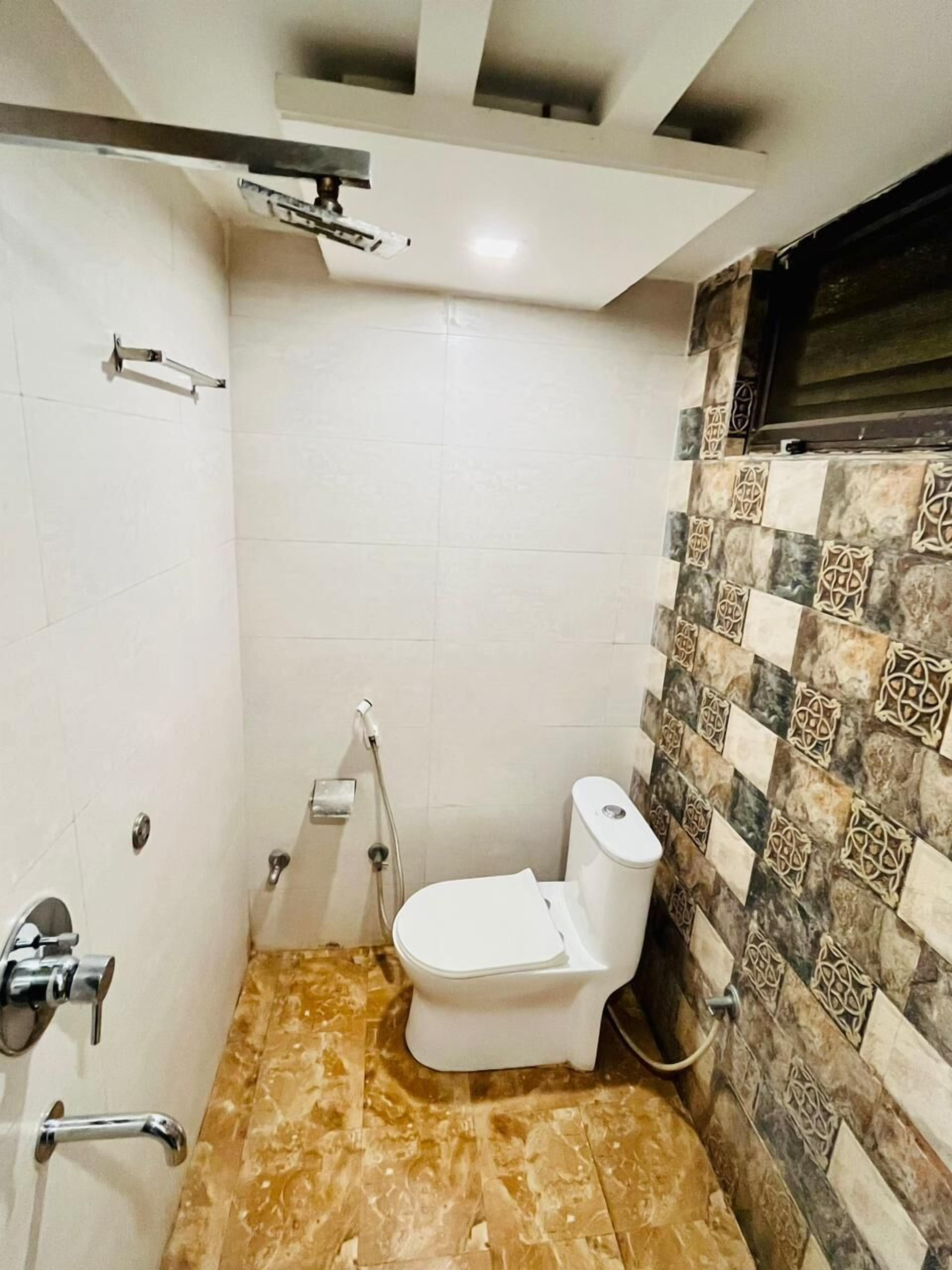 A small bathroom with a toilet, shower, and tiled walls.