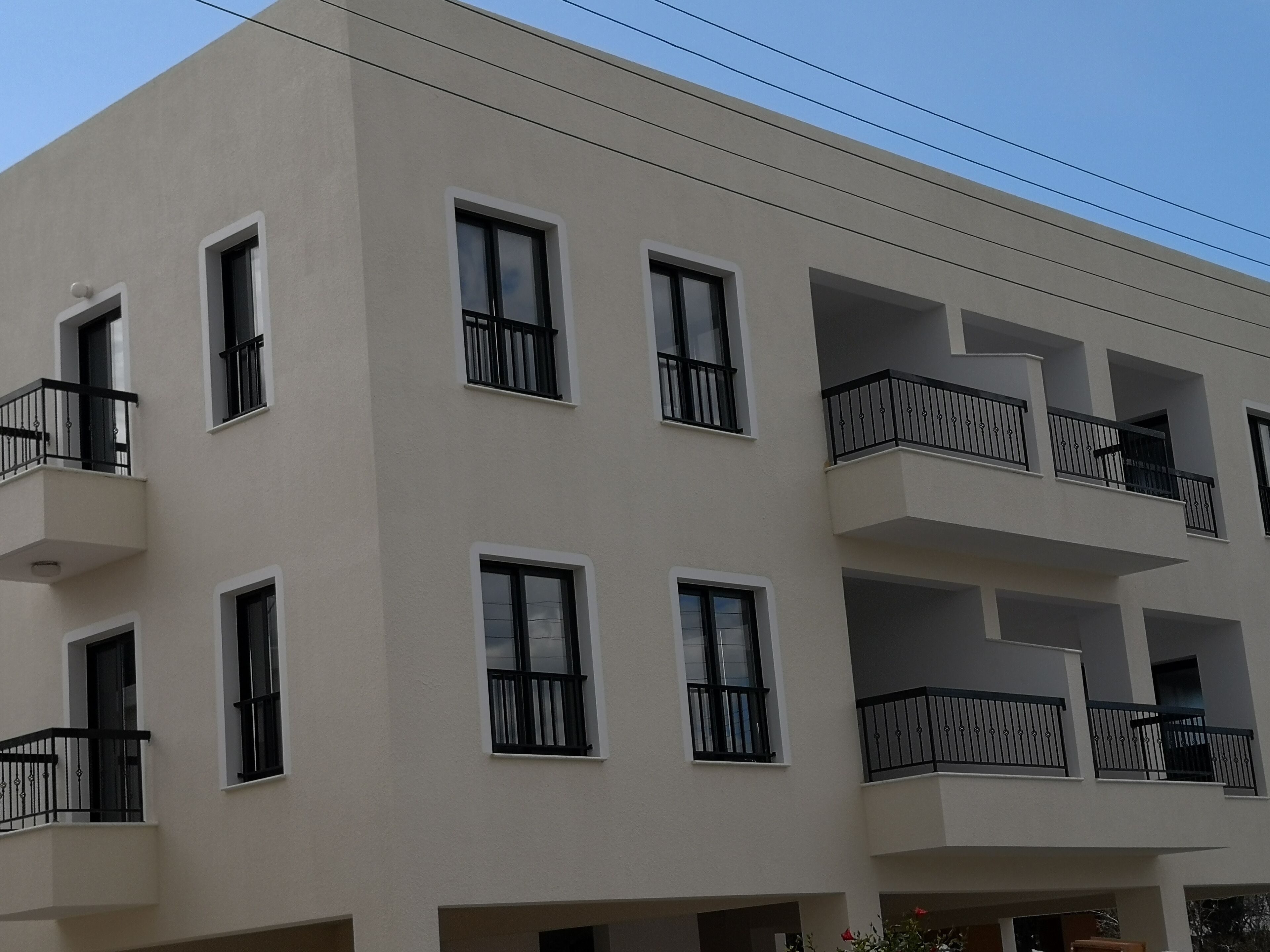 A multi-story building with balconies, rectangular windows, and a flat facade.