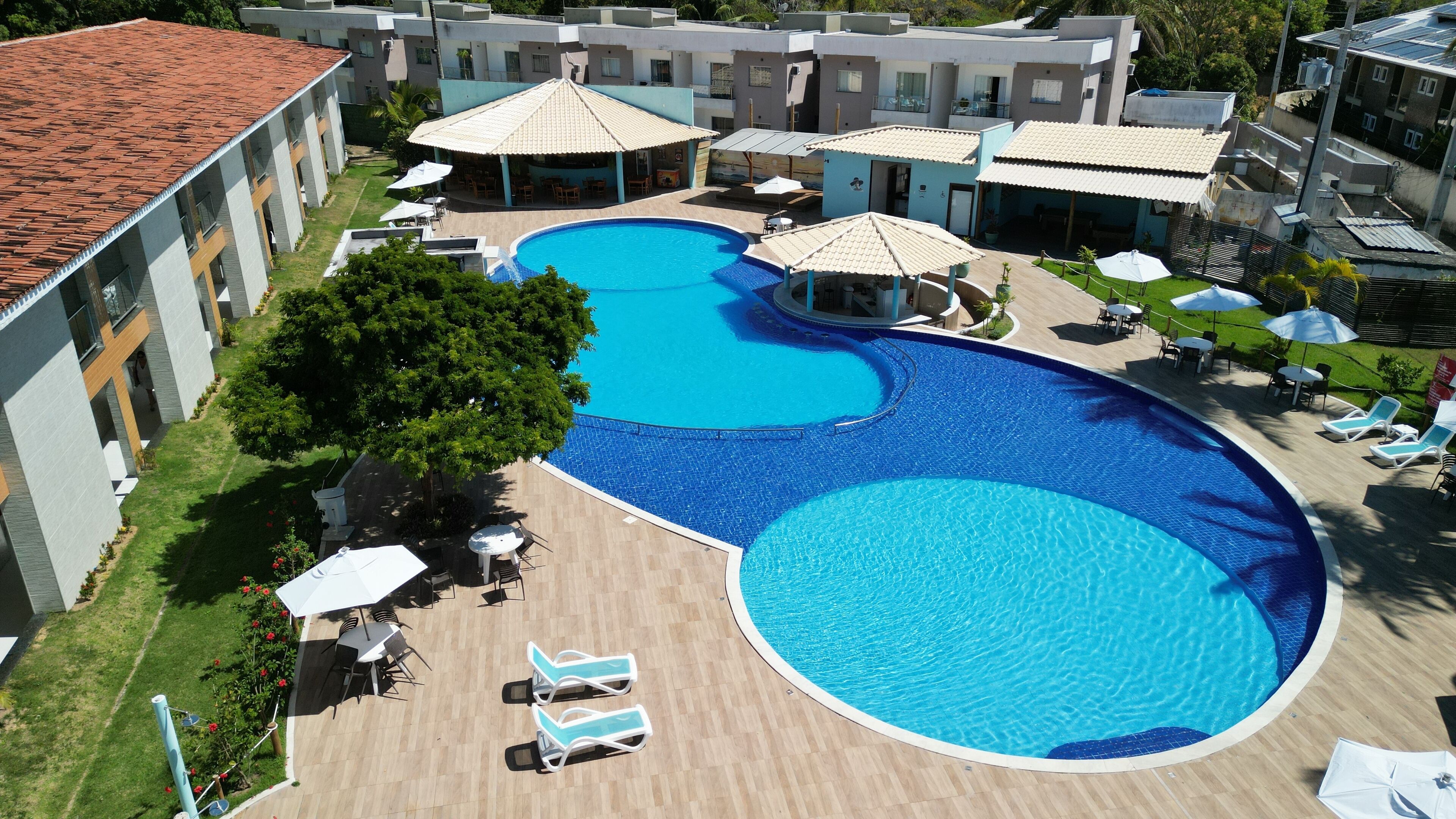 Una piscina al aire libre, sillones reclinables de piscina