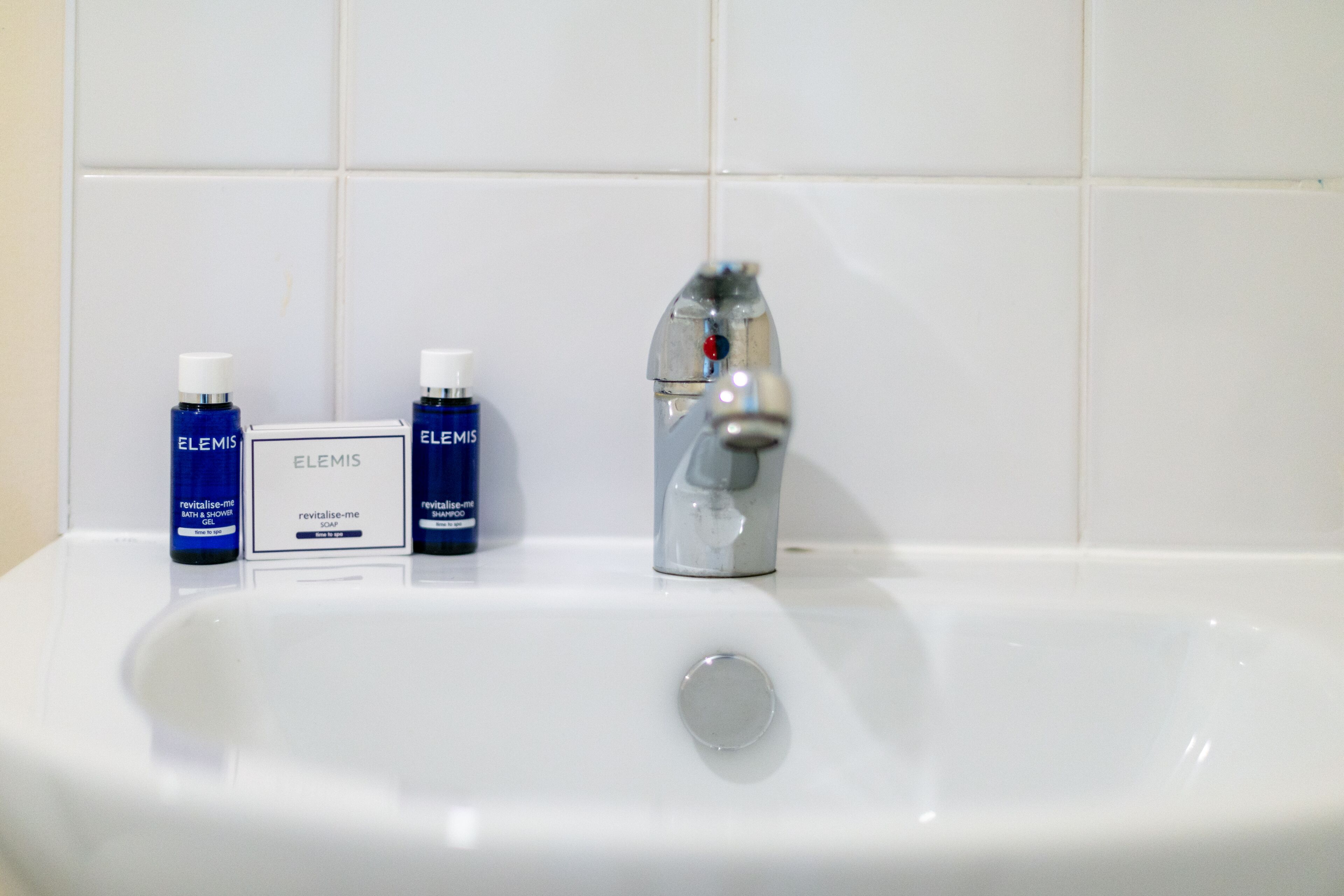 A bathroom sink with two Elemis soap bottles and a Elemis soap bar.