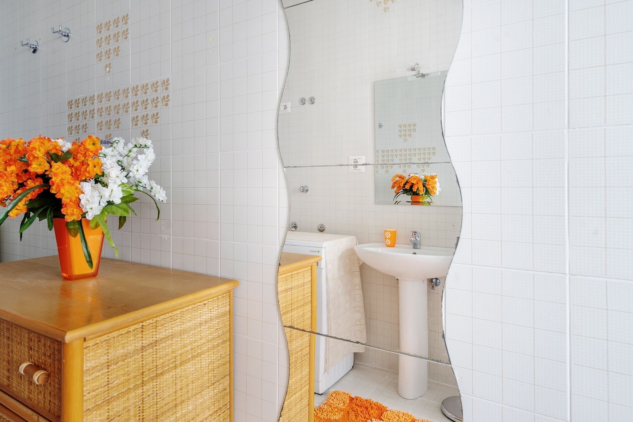 A bathroom with a wooden vanity, a sink, and a mirror.