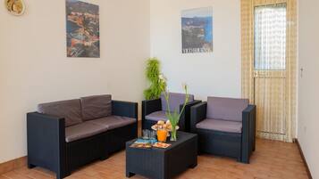 Appartamento, 2 camere da letto, patio, vista mare | Area soggiorno | TV a schermo piatto 32 pollici con canali satellitari, TV