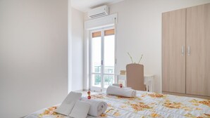 Een hotelkamer met een bed, een kledingkast, een bureau en een balkon.