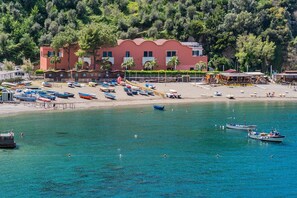 Un bâtiment situé sur la côte, avec une plage au premier plan.