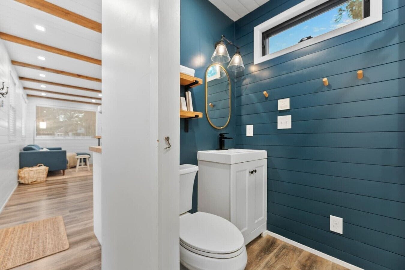 A bathroom with a white toilet, a mirror, and a window.