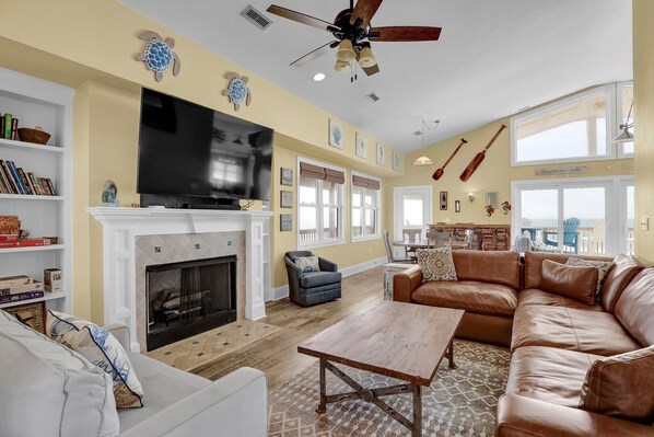 A living room with a fireplace, television, and leather sofa.