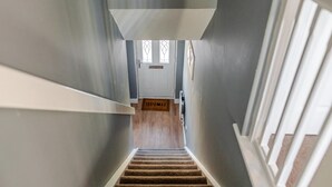 A staircase leading to a door with a doormat. - Modern 4 Bedroom Detached House in Cardiff (Cardiff)