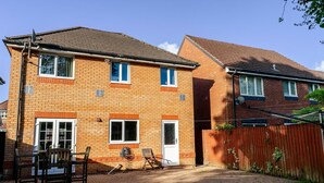 A two-story residential building with a brick facade, a front door, and a visible garage door. - Modern 4 Bedroom Detached House in Cardiff (Cardiff)