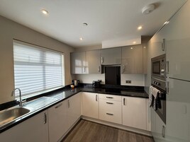 Una cocina moderna con un lavamanos, estufa, microondas y armarios.