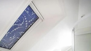 Un baño moderno con tragaluz, inodoro, lavabo y ducha.