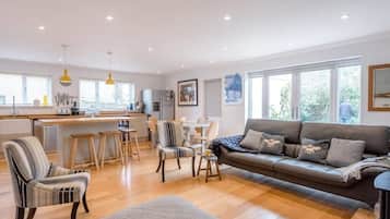 A spacious living area with a sofa, chairs, and a dining table.