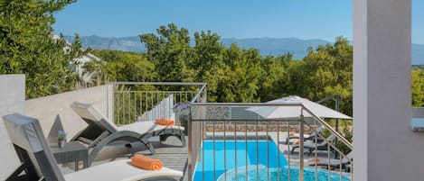 Ein Poolbereich mit Liegestühlen und Bergblick.