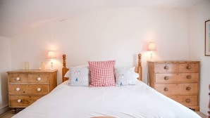 A bedroom with a wooden bed, two nightstands with lamps, and a dresser.