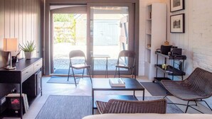 A modern room with a sofa, two chairs, a small table, a TV, and a bookshelf. - The Loose Box, Sudbourne (Sudbourne)