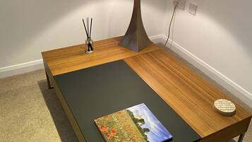 Une chambre moderne avec une table basse en bois, une lampe et un livre.