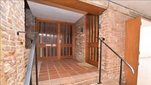 A staircase with a metal handrail leading to a wooden door with a number plate. - Bellfosters (King's Lynn)