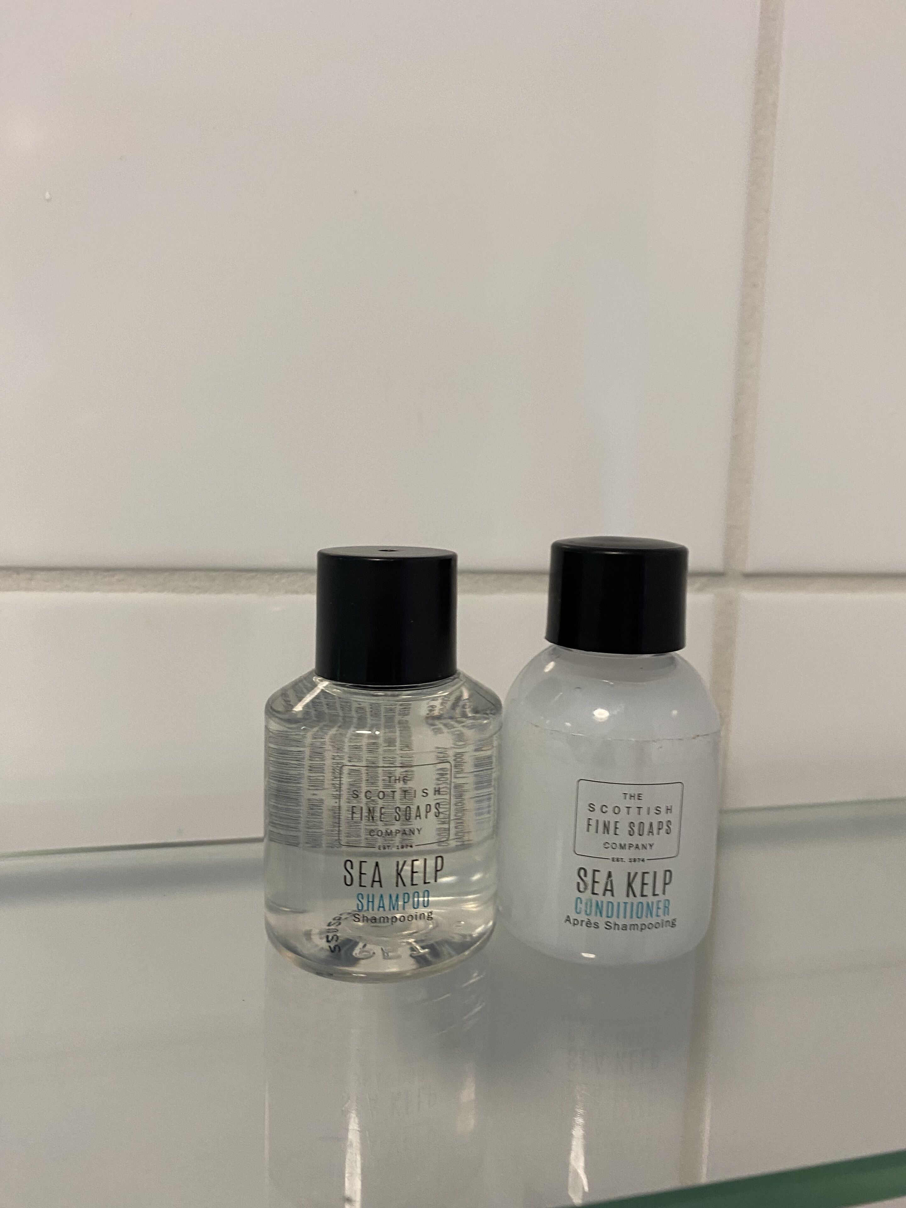 Two bottles of Sea Kelp Shampoo and Conditioner on a glass shelf.