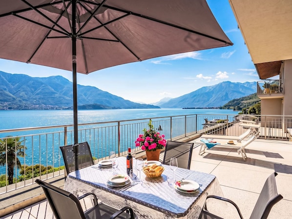 A table set for two with a view of a lake and mountains.