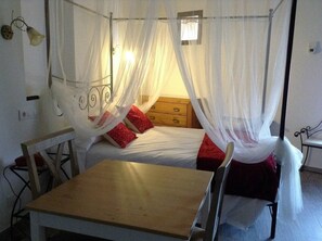 Cozy retreat with a single bed, nightstand, and comfortable seating area.