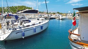 A marina with several boats docked, including a white yacht with blue accents and a cabin. - Lovely apartment in villa for 6 guests with A/C, pool, TV and terrace (San Teodoro)