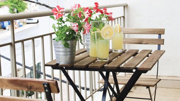 A wooden table with two metal buckets and two glasses of lemonade on a balcony. - Anivia Apartment Airport by Airstay (Spata-Artemida)