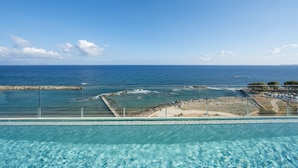 Ein Pool mit Blick auf den Ozean und eine felsige Küste.