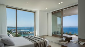 Ein modernes Hotelzimmer mit einem großen Bett, einem Schreibtisch und Meerblick.