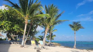 Rannalla, aurinkotuoleja, rantapyyhkeitä