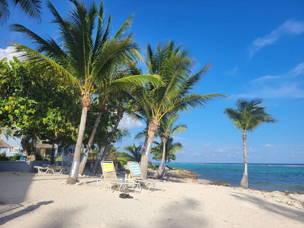 Rannalla, aurinkotuoleja, rantapyyhkeitä