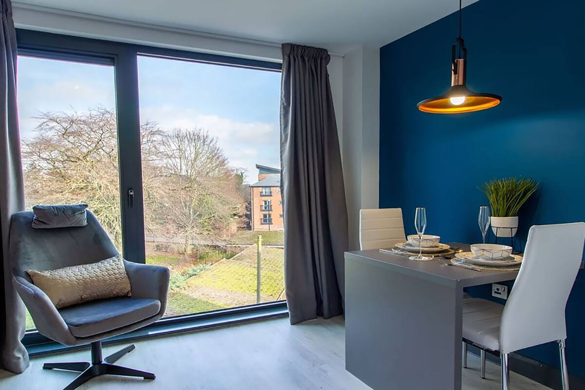 A modern room with a dining table, a chair, and a sofa.