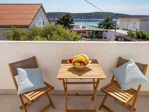 Enjoy a serene view of the water from this outdoor space, featuring a table and chairs for two.