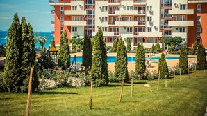 Un hôtel à plusieurs étages doté d’une piscine et d’un jardin aménagé.