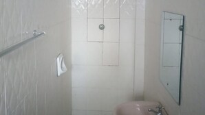 A bathroom with a shower, a sink, a mirror, and a towel dispenser. - Sunvasha Hotel (Naivasha)