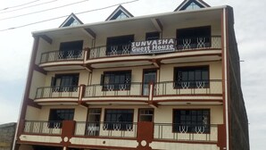 A multi-story building with balconies and a sign that reads "SUNVASA Guest House Restaurant & Accommodation". - Sunvasha Hotel (Naivasha)