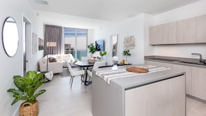 A modern apartment with a central island, a dining area, a living room, and a kitchen. - 43rd Floor Penthouse Ocean Views Private Terraces (Hollywood)